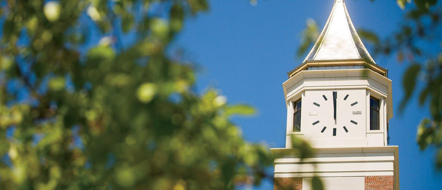 the top of Elliott Tower in focus with blurry tree branches in front