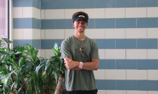 Khalil Roy standing by a plant, smiling at the camera.