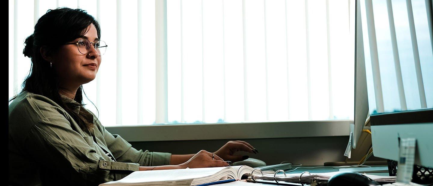 young woman sitting at a table with binders and books